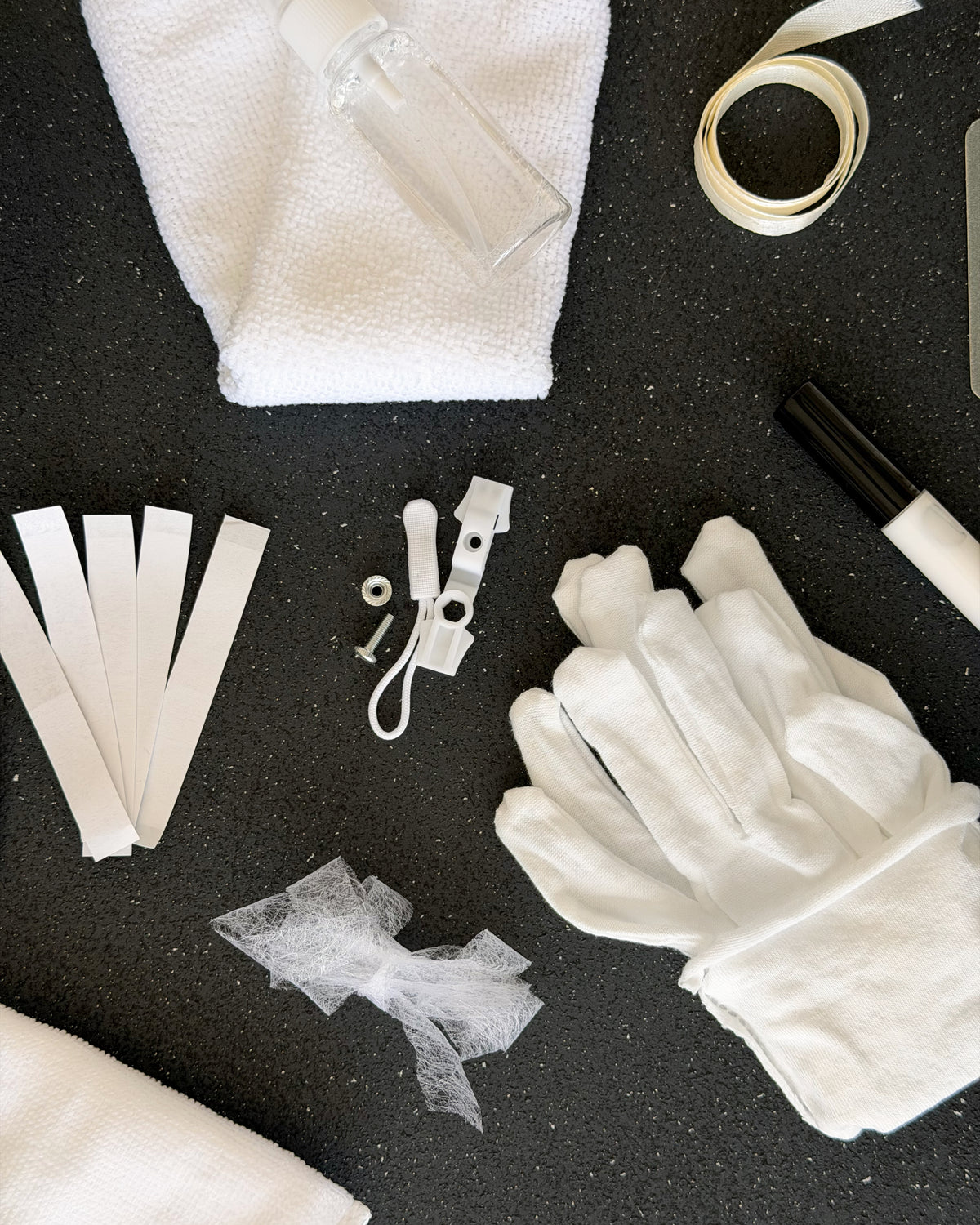 Close up of the bridal emergency kit, cotton gloves, stain remover spray, microfibre cloth and ribbon