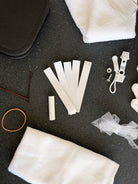 Close up of the bridal emergency kit, hair tie, bobby pins, hem tape strips and emergency zip