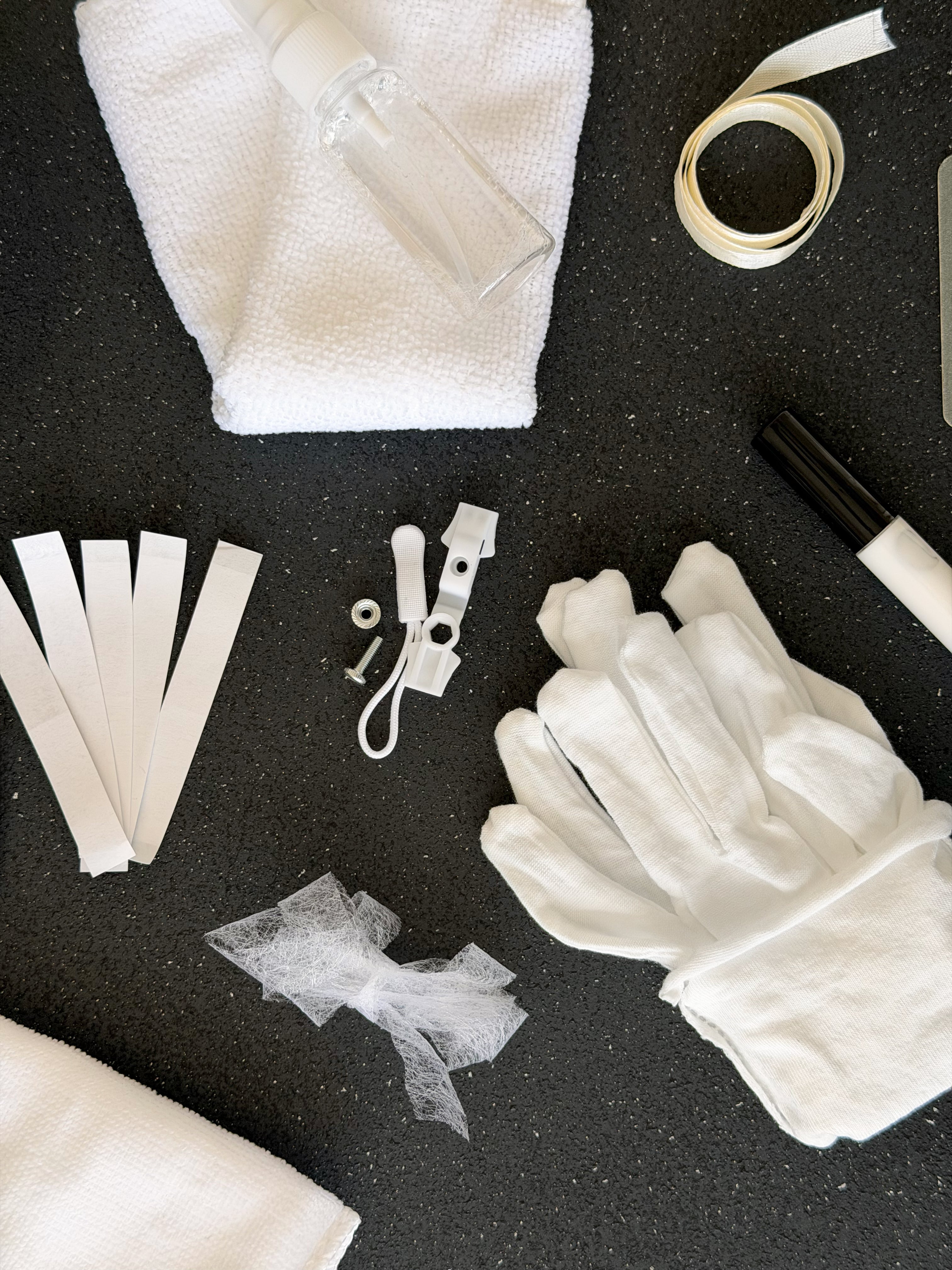 Close up of the bridal emergency kit, cotton gloves, stain remover spray, microfibre cloth and ribbon