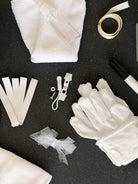 Close up of the bridal emergency kit, cotton gloves, stain remover spray, microfibre cloth and ribbon