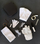 Bridal emergency kit contents laid out, cotton gloves, stain remover, sewing kit, hem tape, ribbon and flannel